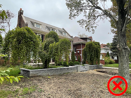 An incorrect example of grading from 848 Chicago in Boston-Edison is show. With the house having a retaining walls that do not give the lawn any slope.