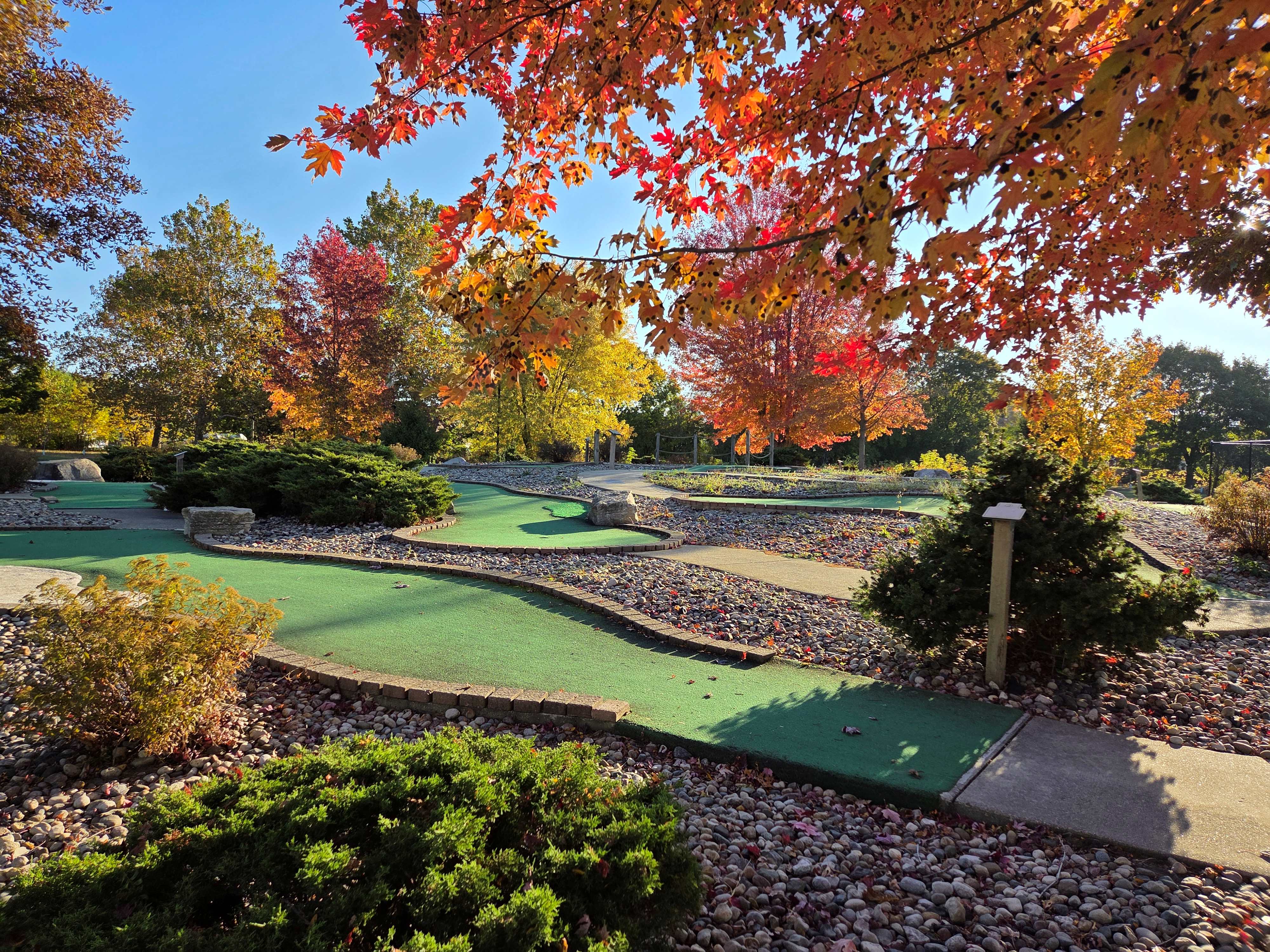 Image of the mini golf area surrounded by trees at Lasky Park on a sunny day in autumn. 