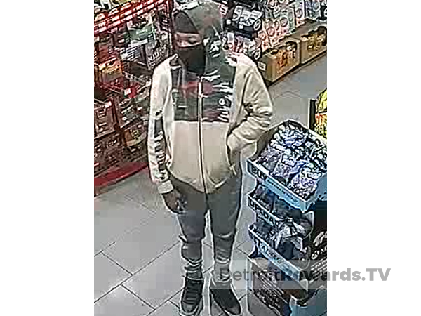 Suspect, a Black male wearing a tan and camoflauge jacket with a hood and black mask. 